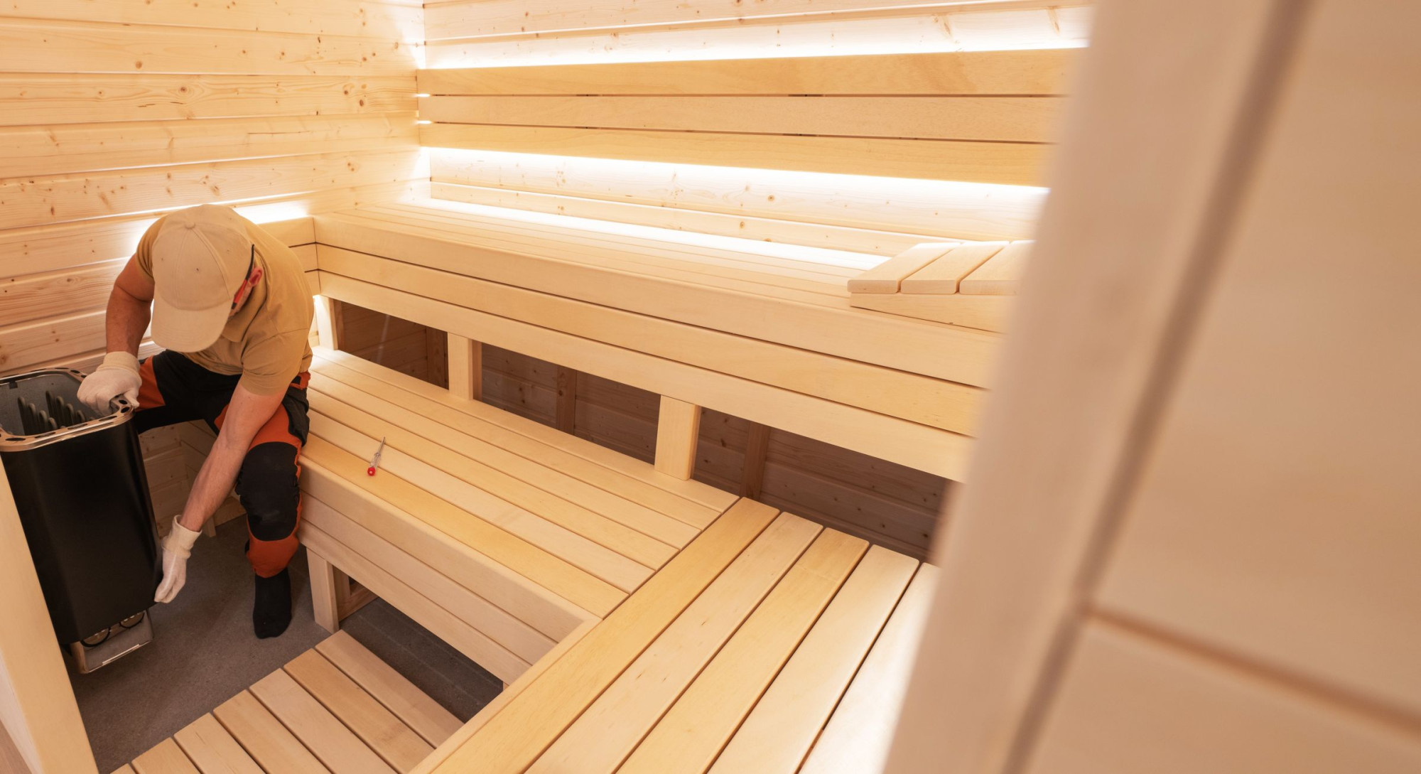 Specialist installeert elektrische verwarming in sauna